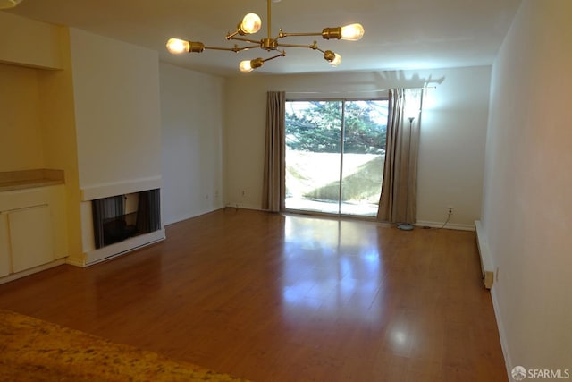 unfurnished living room featuring hardwood / wood-style floors and a notable chandelier