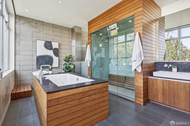 bathroom featuring independent shower and bath, vanity, tile walls, and tile patterned flooring