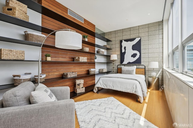 bedroom featuring light hardwood / wood-style flooring and tile walls