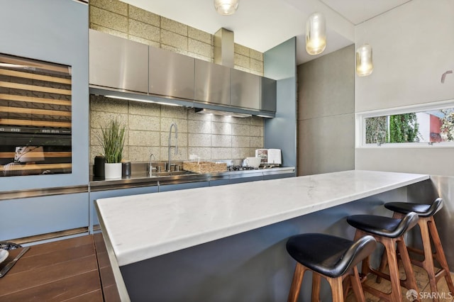 kitchen with hanging light fixtures, decorative backsplash, and sink