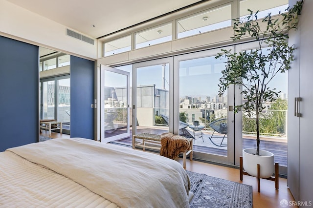 bedroom featuring multiple windows, hardwood / wood-style flooring, and access to exterior