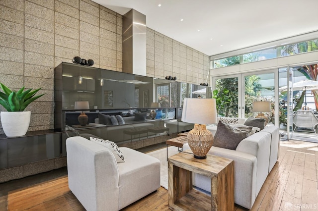 living room with wood-type flooring and a towering ceiling