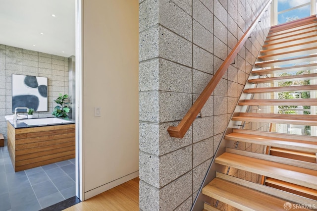 staircase with wood-type flooring and sink