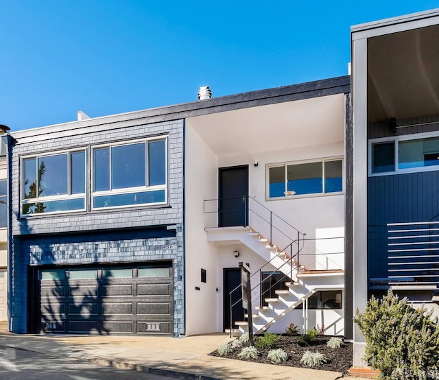 view of front of house featuring a garage, stairs, concrete driveway, and stucco siding