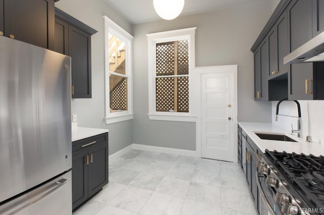 245 Scott St, San Francisco, CA 94117 - kitchen featuring baseboards, light countertops, exhaust hood, stainless steel appliances, and a sink