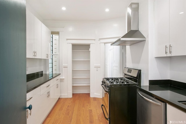 kitchen with island range hood, stainless steel appliances, light hardwood / wood-style flooring, and white cabinets