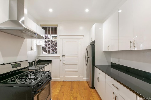 kitchen with island exhaust hood, appliances with stainless steel finishes, sink, and white cabinets