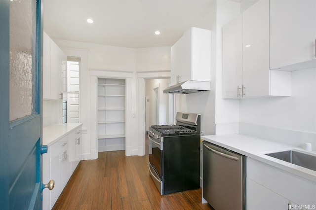 kitchen featuring dark wood-type flooring, appliances with stainless steel finishes, built in shelves, and white cabinets