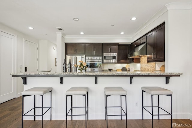 176 Summit Way, San Francisco, CA 94132 - kitchen featuring built in appliances, extractor fan, a breakfast bar, dark brown cabinetry, and recessed lighting