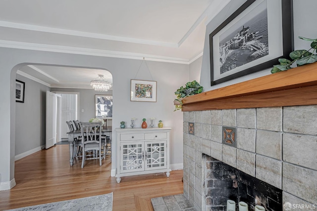 1655 24th Ave, San Francisco, CA 94122 - living area with wood finished floors, arched walkways, baseboards, a fireplace with flush hearth, and crown molding