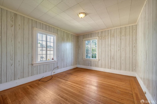 unfurnished room featuring ornamental molding, hardwood / wood-style floors, and baseboards