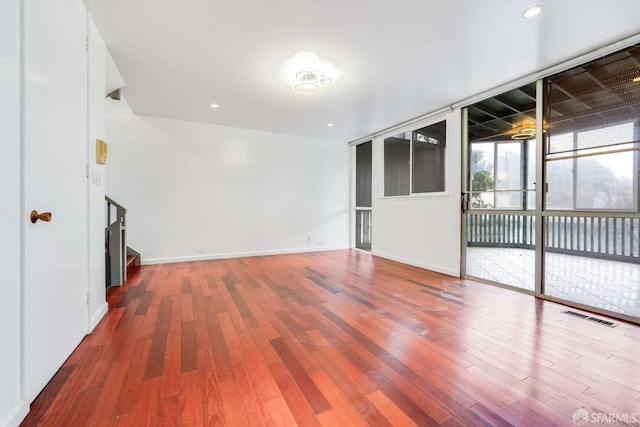 empty room featuring hardwood / wood-style flooring and expansive windows