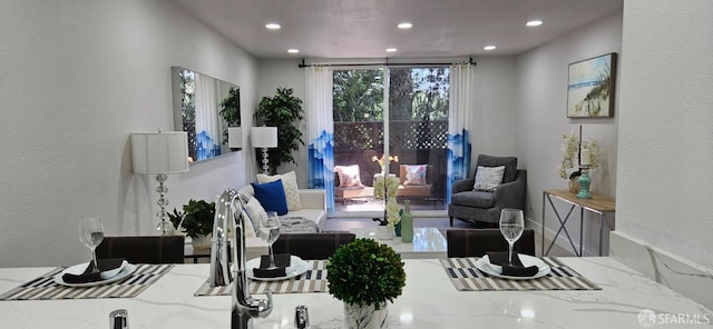 living area featuring recessed lighting and a textured wall