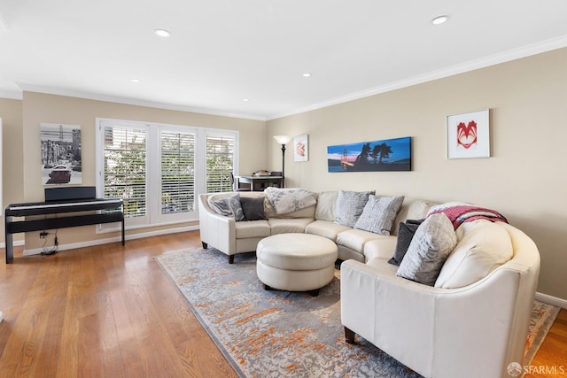 living area featuring baseboards, crown molding, and wood finished floors