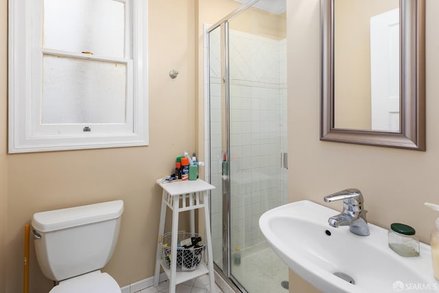 bathroom with toilet, a stall shower, and a sink