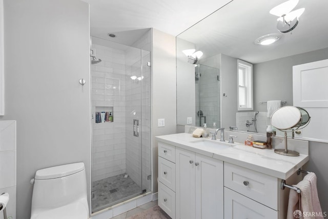 full bathroom featuring a shower stall, toilet, and vanity