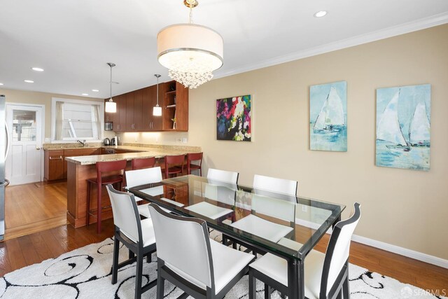 dining space with recessed lighting, baseboards, crown molding, and hardwood / wood-style floors