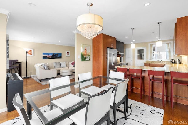 dining area with a chandelier, recessed lighting, baseboards, and wood finished floors