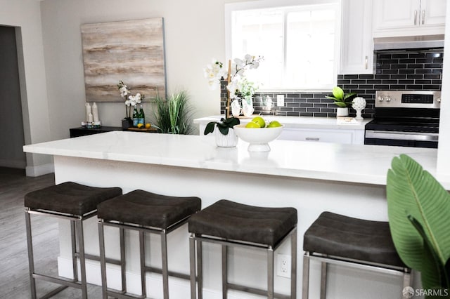 28290 Thackeray Ave, Hayward, CA 94544 - kitchen featuring stainless steel electric range oven, a kitchen breakfast bar, white cabinets, and light countertops
