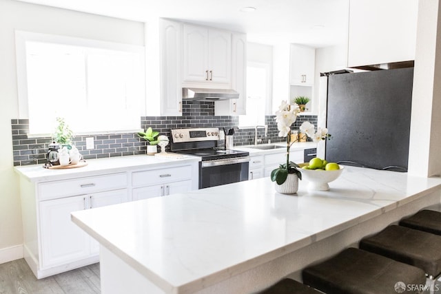 28290 Thackeray Ave, Hayward, CA 94544 - kitchen featuring stainless steel electric range oven, freestanding refrigerator, a kitchen bar, and tasteful backsplash