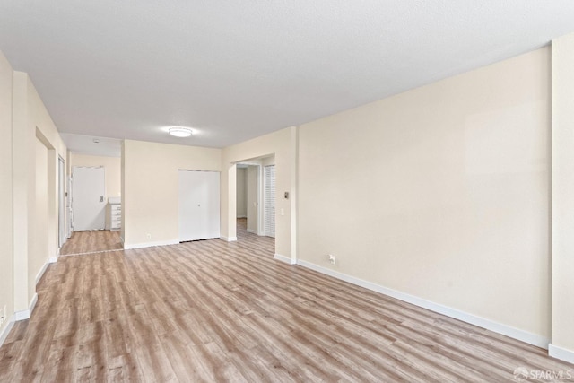 spare room featuring a textured ceiling and light hardwood / wood-style flooring