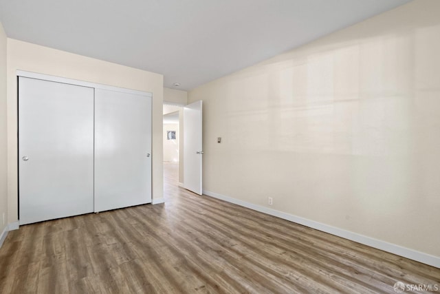 unfurnished bedroom featuring a closet and hardwood / wood-style floors