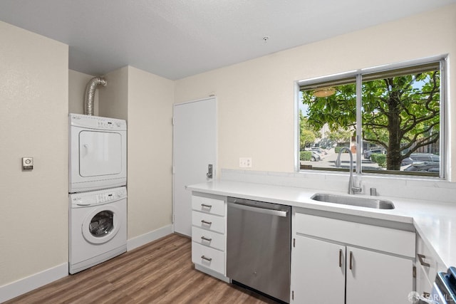 laundry room with stacked washer / dryer, hardwood / wood-style flooring, and sink