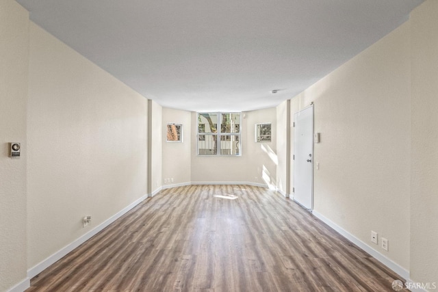 unfurnished room with wood-type flooring