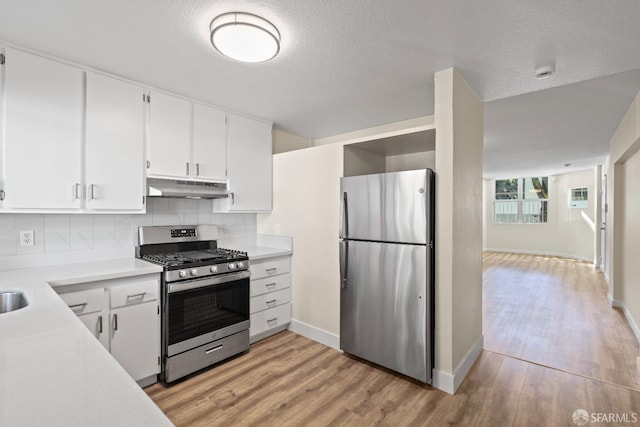 kitchen featuring decorative backsplash, light hardwood / wood-style floors, white cabinetry, and stainless steel appliances