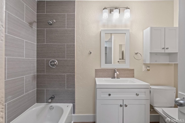 full bathroom with toilet, vanity, and tiled shower / bath combo