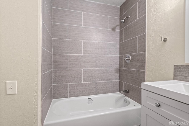 bathroom featuring tiled shower / bath combo and vanity