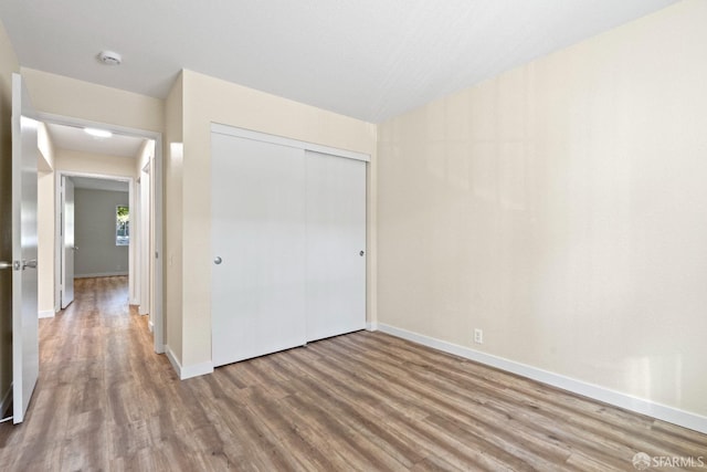 unfurnished bedroom featuring wood-type flooring and a closet