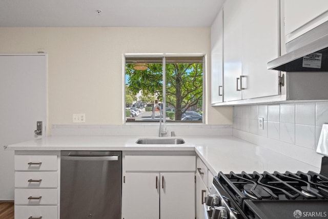 kitchen featuring stainless steel appliances, tasteful backsplash, range hood, white cabinets, and sink