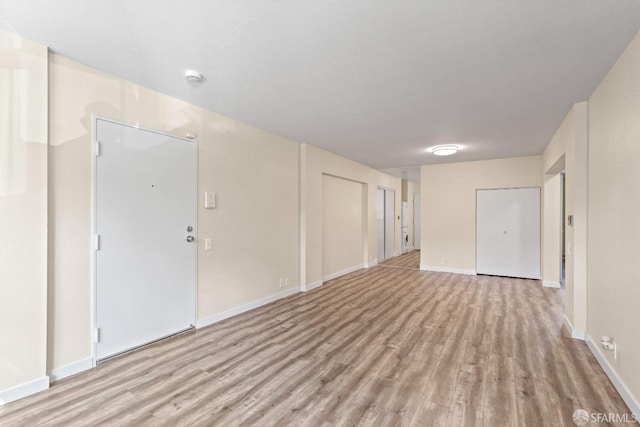 empty room featuring light hardwood / wood-style floors and a textured ceiling