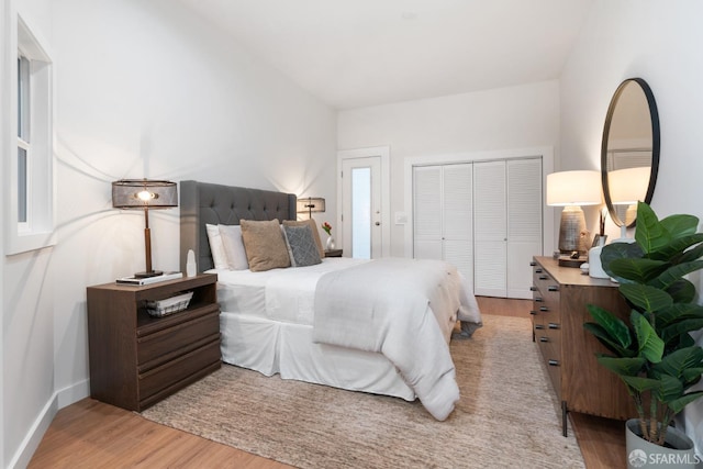 bedroom featuring a closet, baseboards, and light wood-style floors