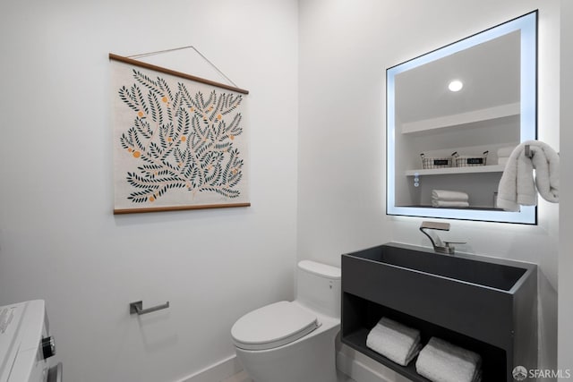 bathroom with toilet, vanity, and baseboards