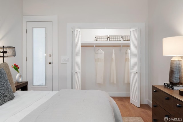 bedroom with light wood-style flooring, a closet, and baseboards