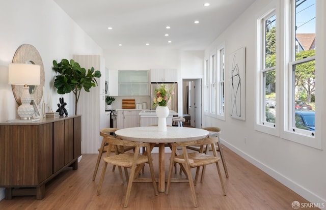 dining area with light wood-style flooring, recessed lighting, and baseboards