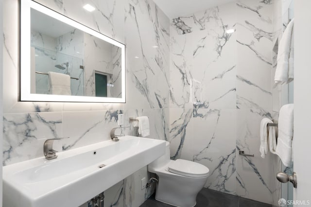 full bathroom featuring a marble finish shower, toilet, and stone wall