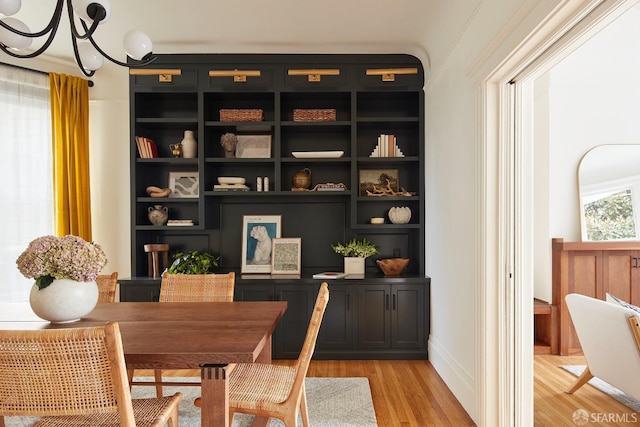 home office with a notable chandelier and light hardwood / wood-style flooring