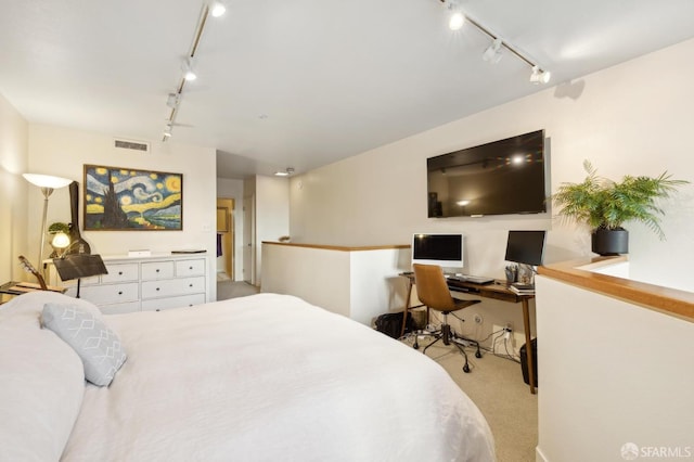 carpeted bedroom featuring rail lighting