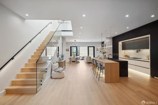 interior space featuring sink, an inviting chandelier, and light wood-type flooring