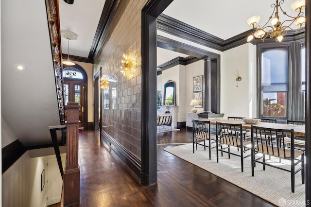 interior space featuring ornate columns, a notable chandelier, dark parquet floors, and a wealth of natural light