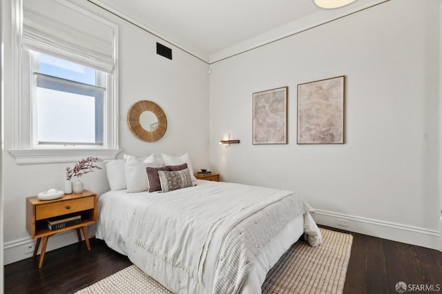 bedroom with dark hardwood / wood-style flooring