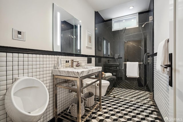 bathroom featuring tile walls, a shower with door, and toilet