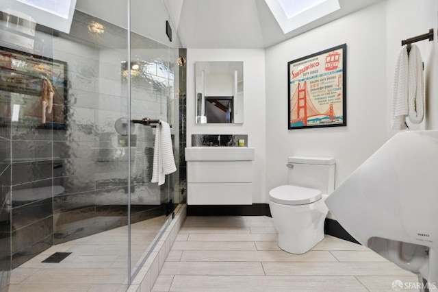 bathroom with toilet, vanity, lofted ceiling with skylight, and walk in shower