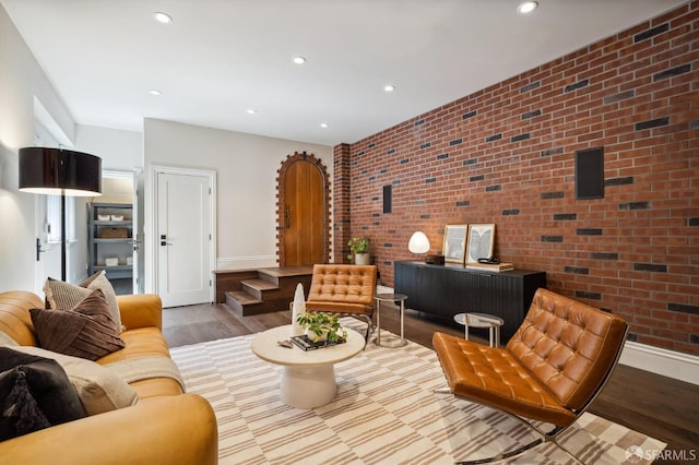 living room featuring hardwood / wood-style floors and brick wall