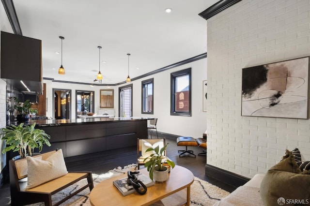 living room featuring crown molding, brick wall, and hardwood / wood-style floors