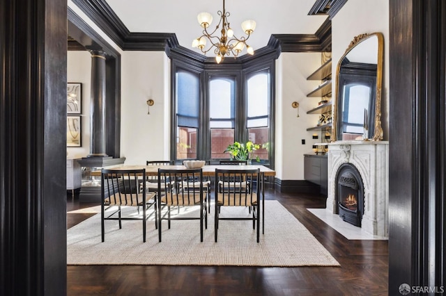 dining space with decorative columns, ornamental molding, dark parquet floors, and a chandelier