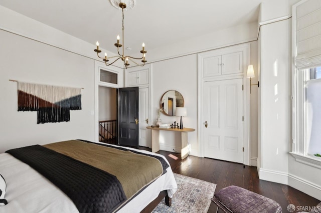 bedroom with dark wood-type flooring, a chandelier, and a closet